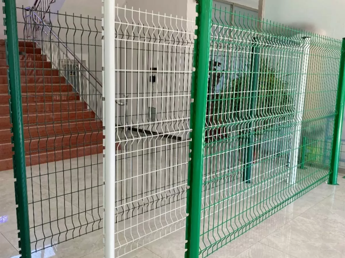 Mesh fence panels standing in a row on their posts along a perimeter run